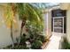 Welcoming front entry featuring a screen door and lush tropical plants at 2403 Nantucket Field Way # 27, Sun City Center, FL 33573