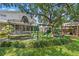 Beautifully landscaped backyard with trampoline, playhouse, swing set, and mature trees at 2403 W Sunset Dr, Tampa, FL 33629