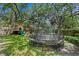 Large backyard with trampoline, swing set, climbing dome, and playhouse offers plenty of outdoor entertainment at 2403 W Sunset Dr, Tampa, FL 33629