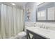 Stylish bathroom with striped shower curtain, marble countertop, and modern fixtures at 2403 W Sunset Dr, Tampa, FL 33629