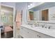 Bright bathroom with double vanity, ladder towel rack and open doorway to bedroom at 2403 W Sunset Dr, Tampa, FL 33629
