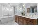 Elegant bathroom with a freestanding tub, double vanity, and chandelier lighting, perfect for relaxation at 2403 W Sunset Dr, Tampa, FL 33629