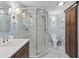 Bright bathroom featuring glass shower with marble tiling, wood cabinet, and modern fixtures at 2403 W Sunset Dr, Tampa, FL 33629