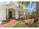 Inviting front porch with brick walkway, lush landscaping, and white columns providing curb appeal at 2403 W Sunset Dr, Tampa, FL 33629