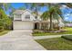 Charming curb appeal: Landscaped front yard, concrete driveway, and a two-car garage at 2403 W Sunset Dr, Tampa, FL 33629