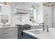 Modern kitchen with stainless steel appliances, white cabinets, and a stylish range hood at 2403 W Sunset Dr, Tampa, FL 33629