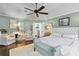 Comfortable main bedroom with hardwood floors, a seating area and a tufted headboard bed at 2403 W Sunset Dr, Tampa, FL 33629