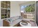 Cozy outdoor patio features a comfortable wicker sofa, decorative pillows, and a round side table at 2403 W Sunset Dr, Tampa, FL 33629