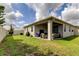 Inviting backyard featuring covered patio with furniture, grill, grassy area, great for entertaining at 2456 Arbor Wind Dr, Lutz, FL 33558
