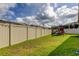 Spacious backyard with lush green lawn, vinyl fence, and a wooden playhouse for Gathering fun at 2456 Arbor Wind Dr, Lutz, FL 33558