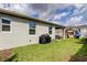 Home exterior with a grill and covered patio surrounded by a green lawn area, ideal for gatherings at 2456 Arbor Wind Dr, Lutz, FL 33558