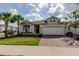 Charming single-Gathering home with a well-manicured lawn, palm trees, and a brick driveway at 2456 Arbor Wind Dr, Lutz, FL 33558
