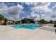 Stunning community pool area with ample lounge seating, modern architectural features, and lush landscaping at 2456 Arbor Wind Dr, Lutz, FL 33558