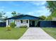 Charming single-story home with a well-manicured lawn, and a carport with chairs at 2606 E 97Th Ave, Tampa, FL 33612