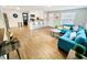 Bright, open-concept living room featuring wood floors, a sectional sofa, and adjacent kitchen with bar seating at 2606 E 97Th Ave, Tampa, FL 33612