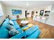 Bright, open-concept living room featuring wood floors, a sectional sofa, and adjacent kitchen at 2606 E 97Th Ave, Tampa, FL 33612