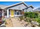 Charming home's front entrance with a bright yellow door and beautiful landscaping at 2611 San Luis Rd, Holiday, FL 34691