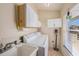 Functional laundry room with sink, washer, dryer, and ample storage cabinets at 2611 San Luis Rd, Holiday, FL 34691