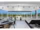 Enclosed porch area with waterfront views, comfortable seating, and stylish outdoor furniture at 2611 San Luis Rd, Holiday, FL 34691