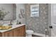 Stylish powder room featuring bird-themed wallpaper, wood vanity, and modern fixtures at 28809 S Orange Berry S Dr, Wesley Chapel, FL 33543