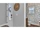 Entryway featuring a decorative wreath on the front door and a glimpse into a patterned wallpapered powder room at 28809 S Orange Berry S Dr, Wesley Chapel, FL 33543