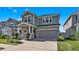 Inviting two-story home with a well-maintained lawn and garden, a covered porch, and attached two-car garage at 28809 S Orange Berry S Dr, Wesley Chapel, FL 33543