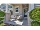 Cozy front porch with seating area, decorative wreath on door, and manicured bushes at 28809 S Orange Berry S Dr, Wesley Chapel, FL 33543