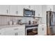 Modern kitchen with white cabinets, stainless steel appliances, and designer backsplash at 28809 S Orange Berry S Dr, Wesley Chapel, FL 33543