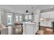 Modern kitchen with white cabinets, island seating, and open view to living space at 28809 S Orange Berry S Dr, Wesley Chapel, FL 33543