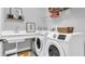 Laundry room featuring a sink, washer, dryer, and storage shelves at 28809 S Orange Berry S Dr, Wesley Chapel, FL 33543