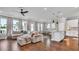Open concept living room with a plush sectional, lots of windows and an island kitchen at 28809 S Orange Berry S Dr, Wesley Chapel, FL 33543