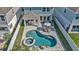 Aerial view of a private backyard oasis featuring a pool, hot tub, patio, and covered outdoor living area at 28809 S Orange Berry S Dr, Wesley Chapel, FL 33543