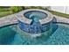 Luxury in-ground pool featuring a custom tiled spa with cascading waterfall, blending elegance and relaxation at 28809 S Orange Berry S Dr, Wesley Chapel, FL 33543