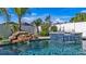 Custom pool featuring a rock waterfall and tiled spa, set amongst lush landscaping and a private backyard fence at 28809 S Orange Berry S Dr, Wesley Chapel, FL 33543
