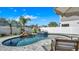 Secluded backyard pool featuring a rock waterfall, tiled spa, and umbrella, providing a private retreat at 28809 S Orange Berry S Dr, Wesley Chapel, FL 33543