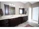 Elegant bathroom featuring double vanities, dark wood cabinets, and tile flooring at 29650 Eagle Station Dr, Wesley Chapel, FL 33543