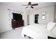 Bedroom with a ceiling fan, television, bed, with access to the ensuite bath and closet at 29650 Eagle Station Dr, Wesley Chapel, FL 33543