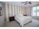 Bedroom features a bed with bedside tables and modern striped accent wall for character at 29650 Eagle Station Dr, Wesley Chapel, FL 33543