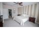 Bedroom features a bed with bedside tables and modern striped accent wall for character at 29650 Eagle Station Dr, Wesley Chapel, FL 33543