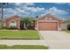 Single-story home featuring a manicured lawn, brick walkway, and two-car garage at 29650 Eagle Station Dr, Wesley Chapel, FL 33543