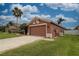 Side view of a single-story home showing the two-car garage and grassy front yard at 29650 Eagle Station Dr, Wesley Chapel, FL 33543