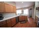 Cozy kitchen area featuring stainless steel dishwasher and sink, complemented by warm wooden cabinets at 29650 Eagle Station Dr, Wesley Chapel, FL 33543