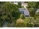 Aerial view of the house showing porch, backyard, well-manicured lawn, and surrounded by mature trees at 3404 W Leona St, Tampa, FL 33629