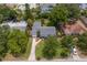 Aerial view of the house showing driveway, mature trees, and a well-maintained yard in a neighborhood setting at 3404 W Leona St, Tampa, FL 33629