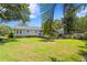 Large backyard with well-kept grass, mature trees, and a wooden deck attached to the house at 3404 W Leona St, Tampa, FL 33629