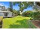 Lush backyard featuring a manicured lawn, wooden deck, and mature trees at 3404 W Leona St, Tampa, FL 33629