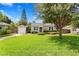 A charming home with a spacious lawn, landscaped gardens, and a detached garage, exuding curb appeal at 3404 W Leona St, Tampa, FL 33629