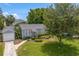 Inviting home exterior with manicured landscaping, detached garage, and walkway at 3404 W Leona St, Tampa, FL 33629