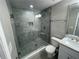 Updated bathroom showcases a tiled shower with glass door, pebble flooring, and a modern vanity at 3718 N 36Th St, Tampa, FL 33610