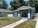 Charming blue bungalow featuring a welcoming front porch with stone accents and a well-manicured lawn at 3718 N 36Th St, Tampa, FL 33610